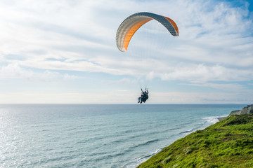 Flying tandem paragliders over the sea and near the mountains, beautiful landscape view