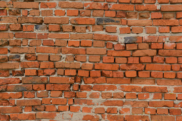 Old brick wall of red brick with uneven rows