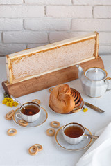 Black tea with buns and honey in honeycomb, whate background