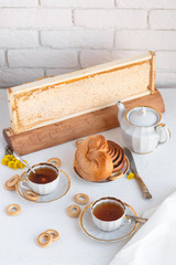 Black tea with buns and honey in honeycomb, whate background