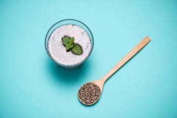 Glass of water with cup of healthy chia seeds and spoon. Text space.