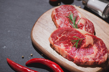Raw beef on a cutting board  with spices and ingredients for cooking.