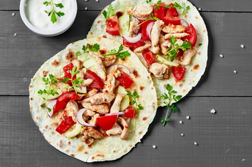 Grilled chicken and fresh vegetables salad tortilla .Healthy delicious breakfast or snack , top view. Flat lay.Outdoors Food Concept