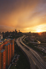 Obraz premium Sky and cloud turn into golden color during sunset overlooking a city where a well built highway giving a unique perspective. Capture in portrait format.