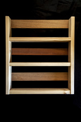 Beautiful wooden shelf from different woods, isolated on black.