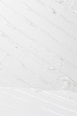 Fototapeta na wymiar White background, rough relief plaster texture. Backdrop with stripes, free space for text. Repair, building, construction work concept.