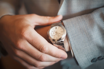 businessman looking at his watch on his hand, watching the time