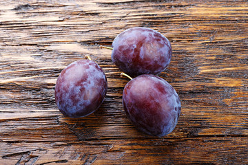 Ripe plums on a wooden background