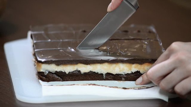 Cutting chocolate cake. Woman's hand cuts cake.