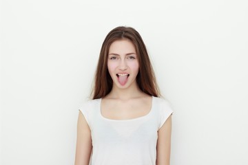 Fototapeta premium Pretty funny young girl showing tongue