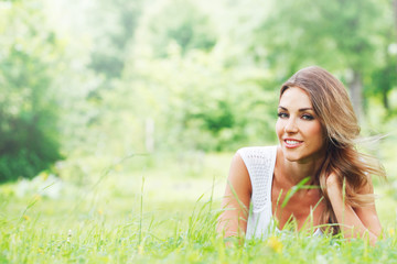 Naklejka na ściany i meble Young woman in white dress on grass