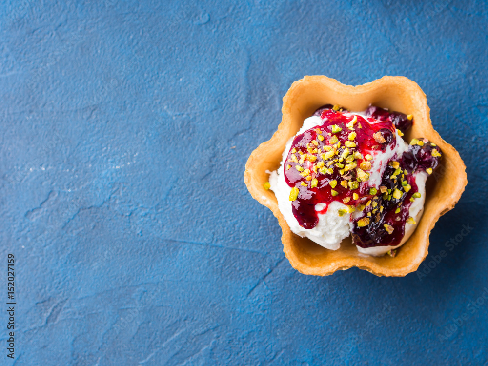 Wall mural vanilla home made ice cream scoops in waffle cup with berry sauce and pistachio nuts. sweet treat