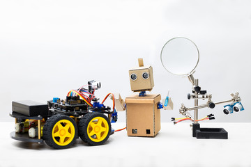 Two robots and parts for assembling a robot on a white background