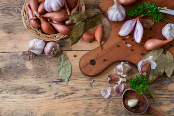 Scattered garlic and onion on a wooden background