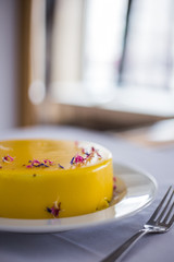 Obraz na płótnie Canvas Culinary blog background. Delicious low sugar lemon cheesecake decorated with flowers served on a white table. Instagram style.