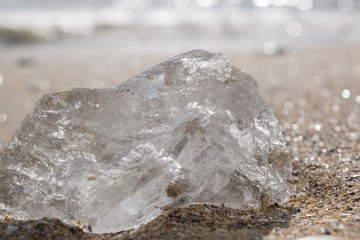 a piece of ice on the beach on a sunny day