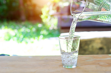 Glass of water on nature background.