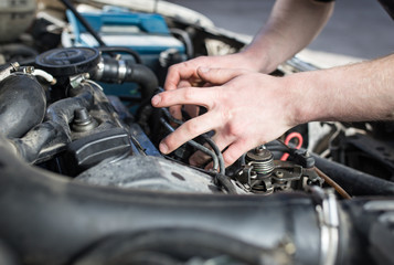 The master repairs under the hood of the car