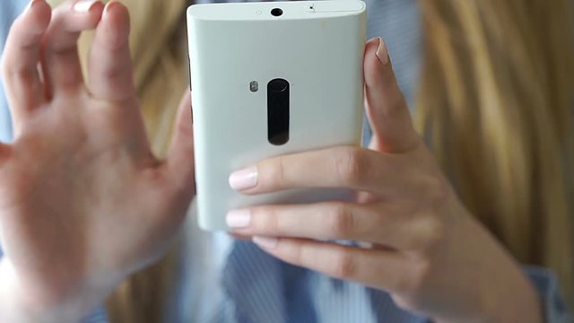 View of girl's hands browsing internet on smartphone
