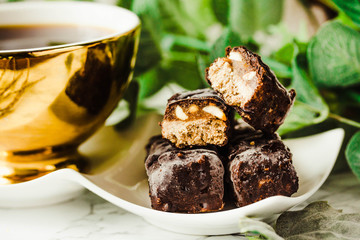 Homemade raw chocolate candy. Snickers bars with cup of coffee.