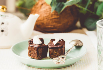 Raw chocolate candy with nuts and coconut, healthy vegan dessert