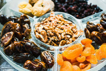 Assorted dried fruits and nuts on a glass plate. Close up.