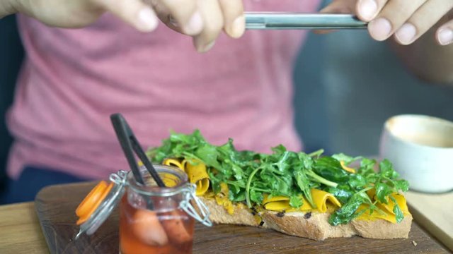 Man taking photo of food and drink with cellphone sitting in cafe 
