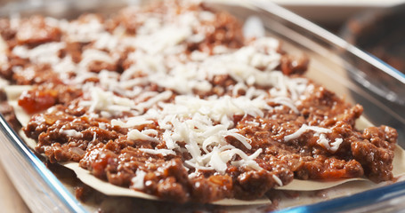 preparing traditional italian lasagna adding cheese, 4k photo