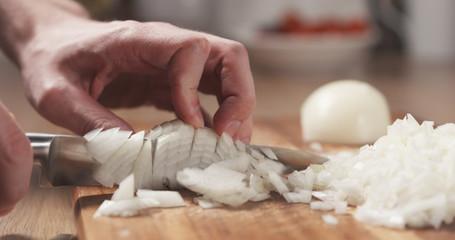 Obraz na płótnie Canvas man cutting white onion with knife, 4k photo