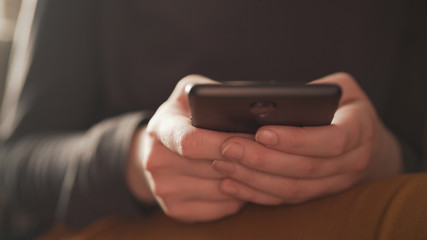 teen girl using smartphone backlit by window light, uhd photo