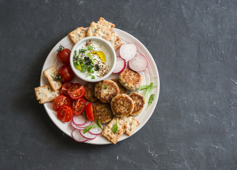 Snack plate. Cauliflower meatballs, tomatoes, radish, gluten-free, cracker and sauce. Healthy vegetarian snack. Top view