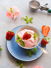 Home made strawberry ice cream in bowl with min leaves