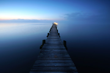 Fototapeta premium samotnie na starym drewnianym pomoście nad jeziorem