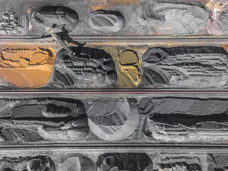 Brown coal deposits. Surface mine with exposed colored minerals and brown coal, mining equipment. View from above.