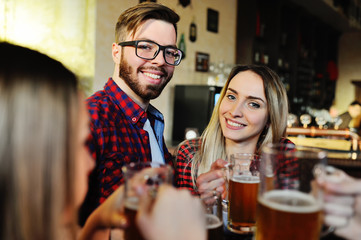 Company friends drink beer and smile