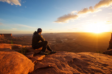 Hiker meets sunset at Grand view  point in Canyonlands National park in Utah, USA - obrazy, fototapety, plakaty