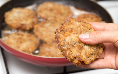 Fried chicken in a frying pan in hand
