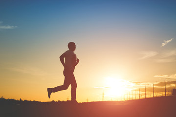 Fototapeta premium Silhouette of running man on sunset background