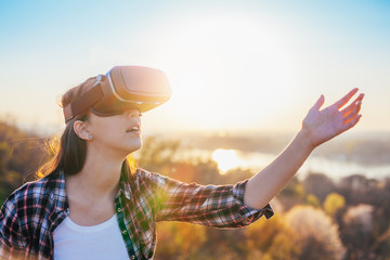 Woman using virtual reality headset outdoor side view