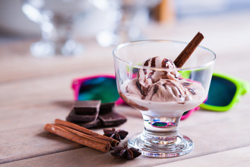 Ice cream sundae, spices, chocolate pieces and sun glasses 