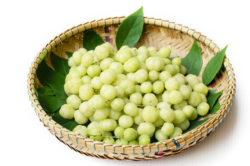 top view fresh Phyllanthus acidus or  star gooseberry with green leaves on bamboo basket background