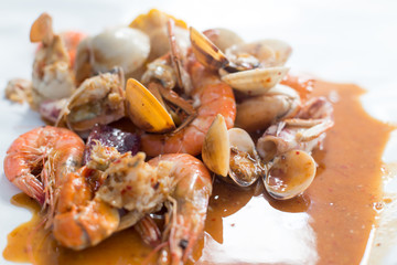 Fried stir spicy sea food for eat on table.