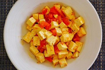 Plate of vegan tofu cubes sauteed with tomatoes