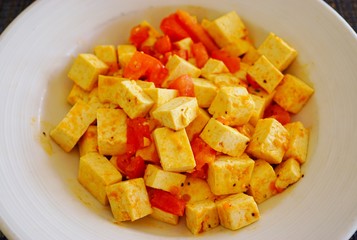Plate of vegan tofu cubes sauteed with tomatoes