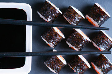 Sushi rolls with salmon, chopsticks and soy sauce 
