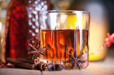 Glass of brandy on the wooden table and spices
