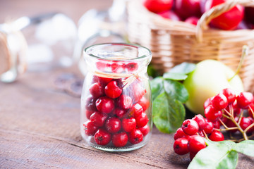 Rowanberry in a glass jars, plums in a basket