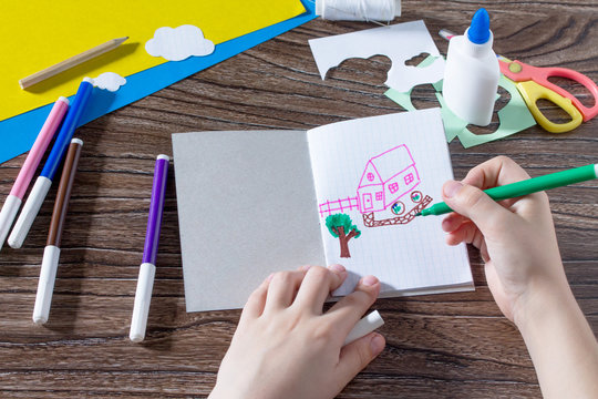 The child draws details. The child creates a note pad handmade applique decorated balloon, craft paper. The project of children's creativity, needlework, crafts for children.