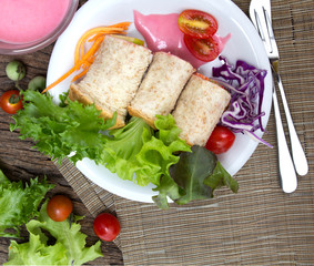 fresh whole wheat bread wraps with vegetables and fruit on the plate , healthy and clean food concept