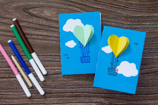 Notepad for entries of handmade balloons and markers decorated with appliqu&eacute;s, paper on a desk, craft of paper. The project of children's creativity, needlework, crafts for children.